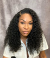 woman wearing e-curly bundles and matching e-curly frontal in it's natural state giving a natural curly look with a grey background