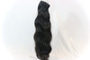 a bundle of black raw hair extensions in the wavy texture against a white surface
