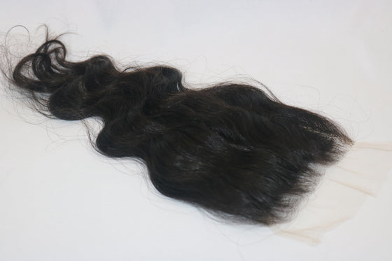 A wavy, black undetectable thin hd lace hair closure with a realistic appearance.