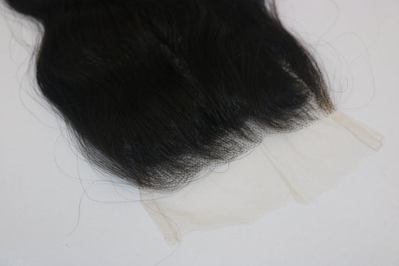 A wavy, black undetectable thin hd lace hair closure with a realistic appearance.