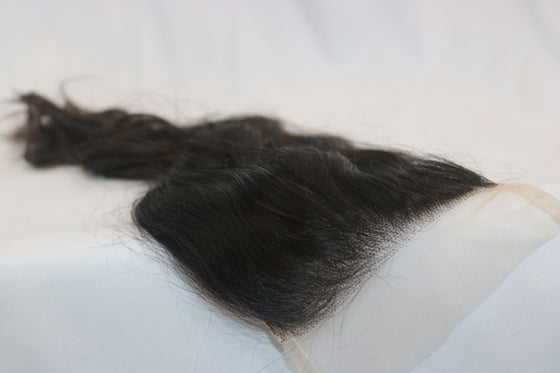 A 5x5 ultra thin transparent closure Indian wavy hair extensions laid out on a white surface.