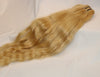 a bundle of blonde 613 wavy hair laid on a white surface