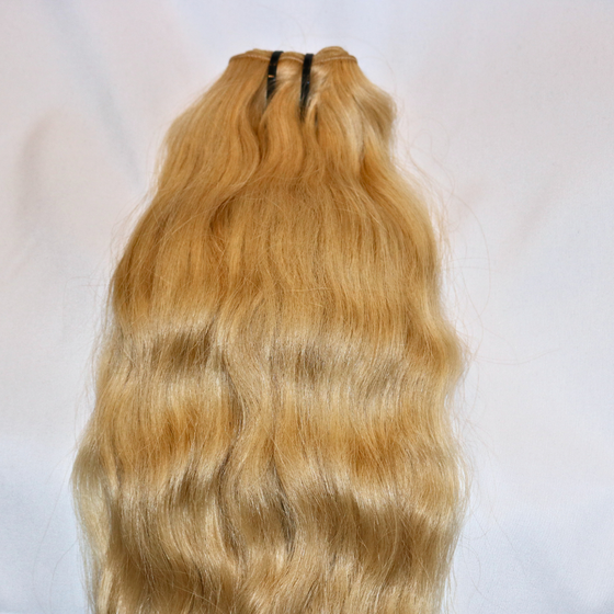a bundle of blonde 613 wavy hair laid on a white surface