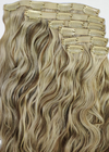 two toned blonde clip in hair extension pieces laying on top of each other with a white background