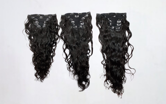 three sets of wavy clip-in hair extension sets laid side by side against a white surface.