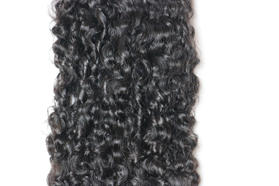 a hair bundle in the e-curly texture laid against a white surface