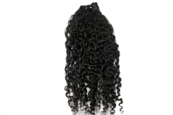 a hair bundle in the e-curly texture laid against a white surface