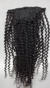 a set of clip in hair extensions in the kinky curly texture laid against a white surface