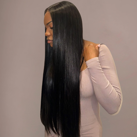 Woman with long straight black hair styled in a straight manner against a neutral background