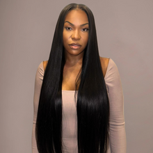  Woman with long straight black hair wearing a beige dress against a gray background