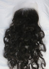 A closure in the texture natural curly laid out on a white surface.